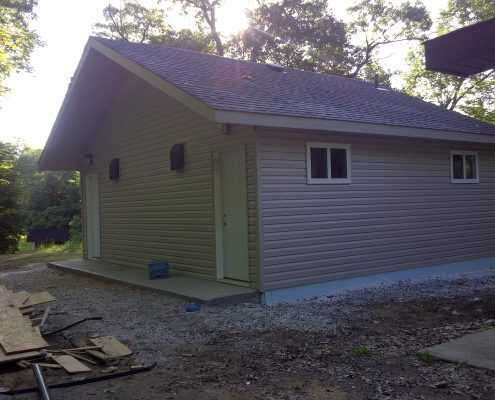 building with vinyl siding, small windows and two doors